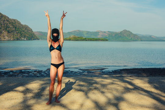 Woman wearing bikini and balaclava on beach