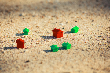 Fototapeta na wymiar Small plastic houses on the beach