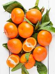 Fresh mandarin fruits on white wood background