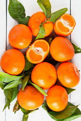Fresh mandarin fruits on white wood background