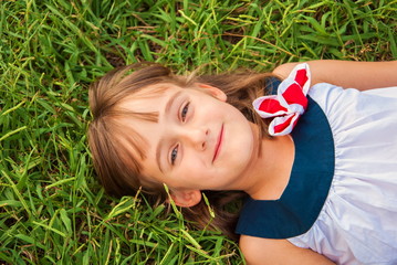 Portrait of a cute little girl on a background of grass