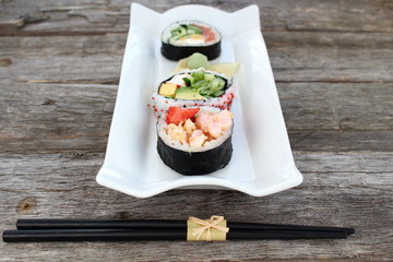 Sushi rolls entry on old wooden board
