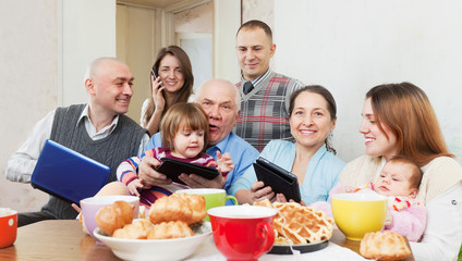 Obraz na płótnie Canvas multigeneration family using electronic devices
