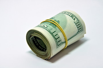 Roll of U.S. banknotes rolled up on white background