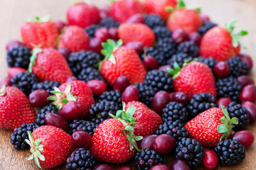 Berries, summer fruit on wooden table.