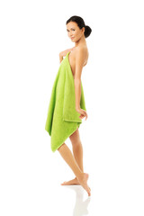 Side view woman standing wrapped in towel