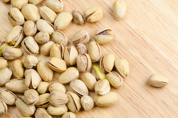 roasted and salted pistachios on wooden background