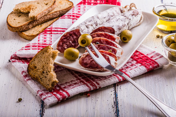 Slices of salami on a white plate