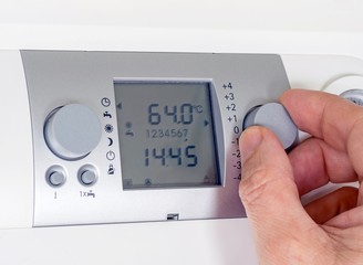 Adjusting the thermostat settings of a household heating system
