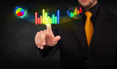 Handsome young business man touching colorful modern graph syste