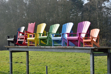 Colorful wooden armchairs on metal structure