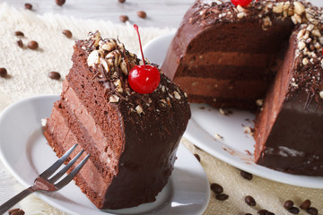 Cut a piece of dark chocolate cake with cherry horizontal
