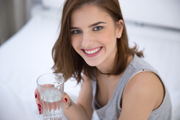 Portrait of a smiling woman holding glass of water