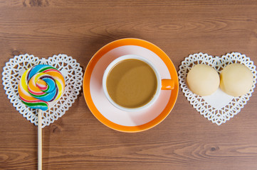 Cup of coffee and candy on a wooden.
