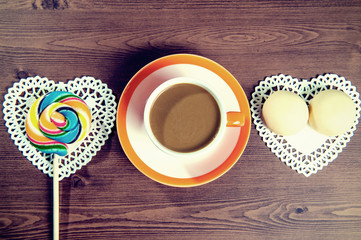 Cup of coffee and candy on a wooden with vintage colour.