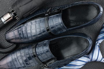 Obraz na płótnie Canvas Classic blue men's shoes, tie, umbrella on the black leather
