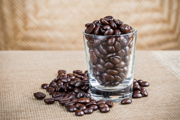 Coffee beans in glass shot with weave background