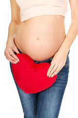 Pregnant woman with a heart pillow