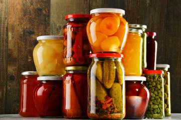 Jars with pickled vegetables, fruity compotes and jams isolated