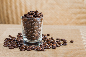 Coffee beans in glass shot with weave background
