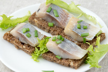 Sandwiches of rye bread with herring and onions