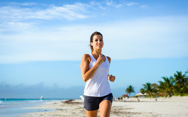 Cheerful woman running at tropical beach
