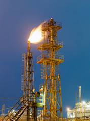 burning torch and industrial tower