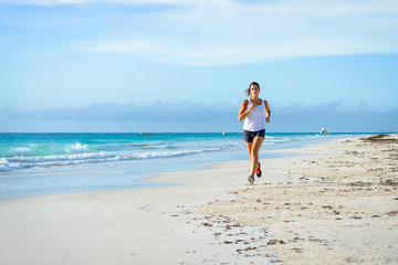 Fototapeta na wymiar Woman running at tropical beach