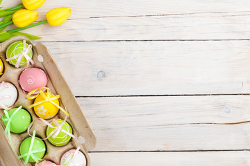Easter background with colorful eggs and yellow tulips