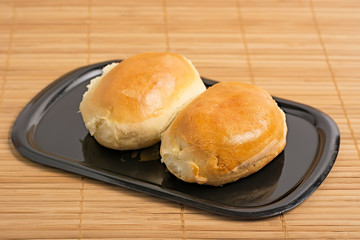 Homemade patties on black tray.