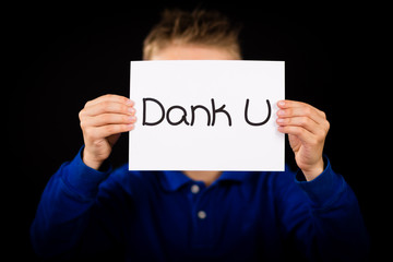 Child holding sign with Dutch words Dank U - Thank You