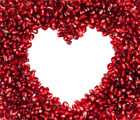 Fresh pomegranate seeds in a heart-shaped isolated on a white