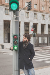Young handsome bearded man posing in the city streets