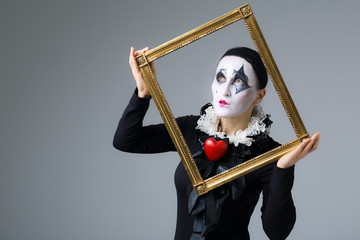 Woman in disguise harlequin in the picture frame
