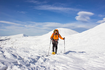 Winter hiking in the mountains on snowshoes .