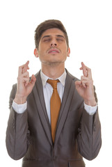 business man fingers crossed eyes closed