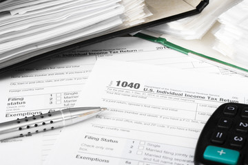 Obraz premium U.S. Individual tax form 1040 with calculator and pen.