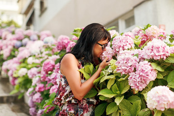 women touches spring hydrangea in garden