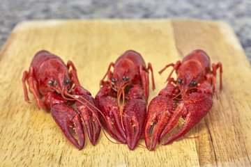 Three lobsters on cutting board