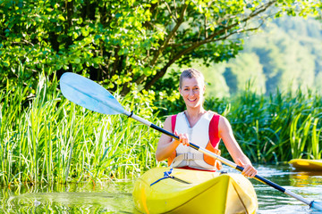 Frau fährt im Kajak auf Wald Fluss 