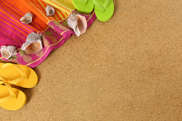 Fototapeta na wymiar Beach sand background with flip flops towel and seashells summer holiday vacation photo