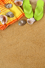 Beach sand background with towel seashells flip flop sandals summer holiday vacation photo vertical