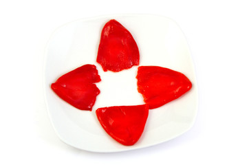 Roasted red peppers in olive oil on a white dish