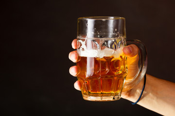 Male hand holding mug of beer