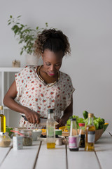 Fototapeta na wymiar Young African Woman Cooking Salad