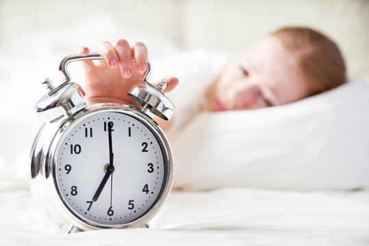 alarm clock and sleeping young woman