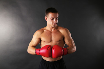 Naklejka na ściany i meble Handsome young muscular sportsman with boxing gloves
