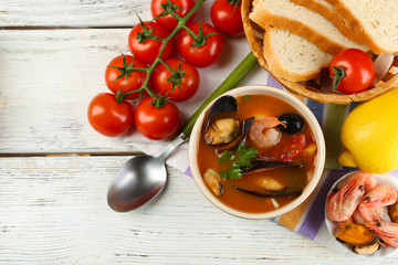 Tasty soup with shrimps, mussels, tomatoes and black olives in