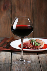Grilled steak in wine sauce with glass of wine