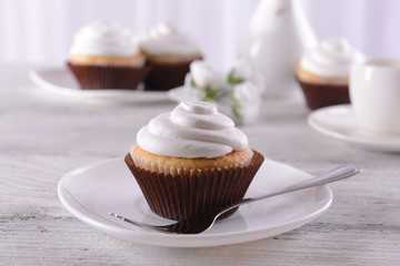 Delicious cupcakes on table on light background
